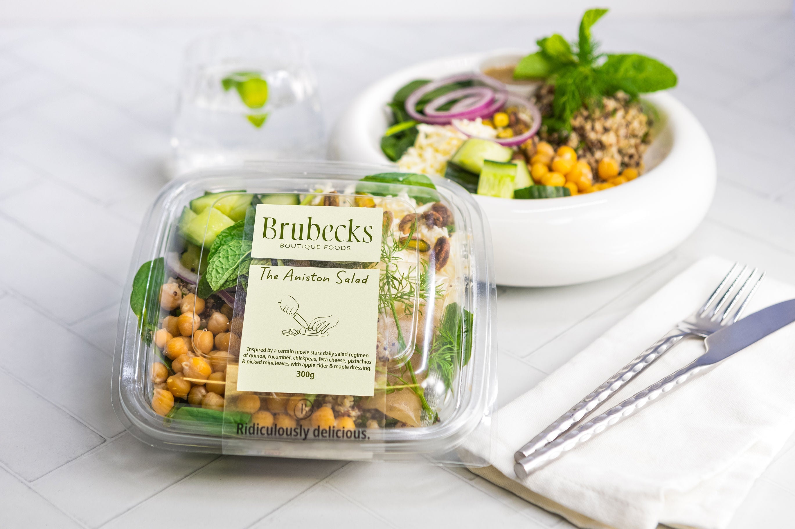 Brubeck's salad packaging with a salad in the background on a white surface