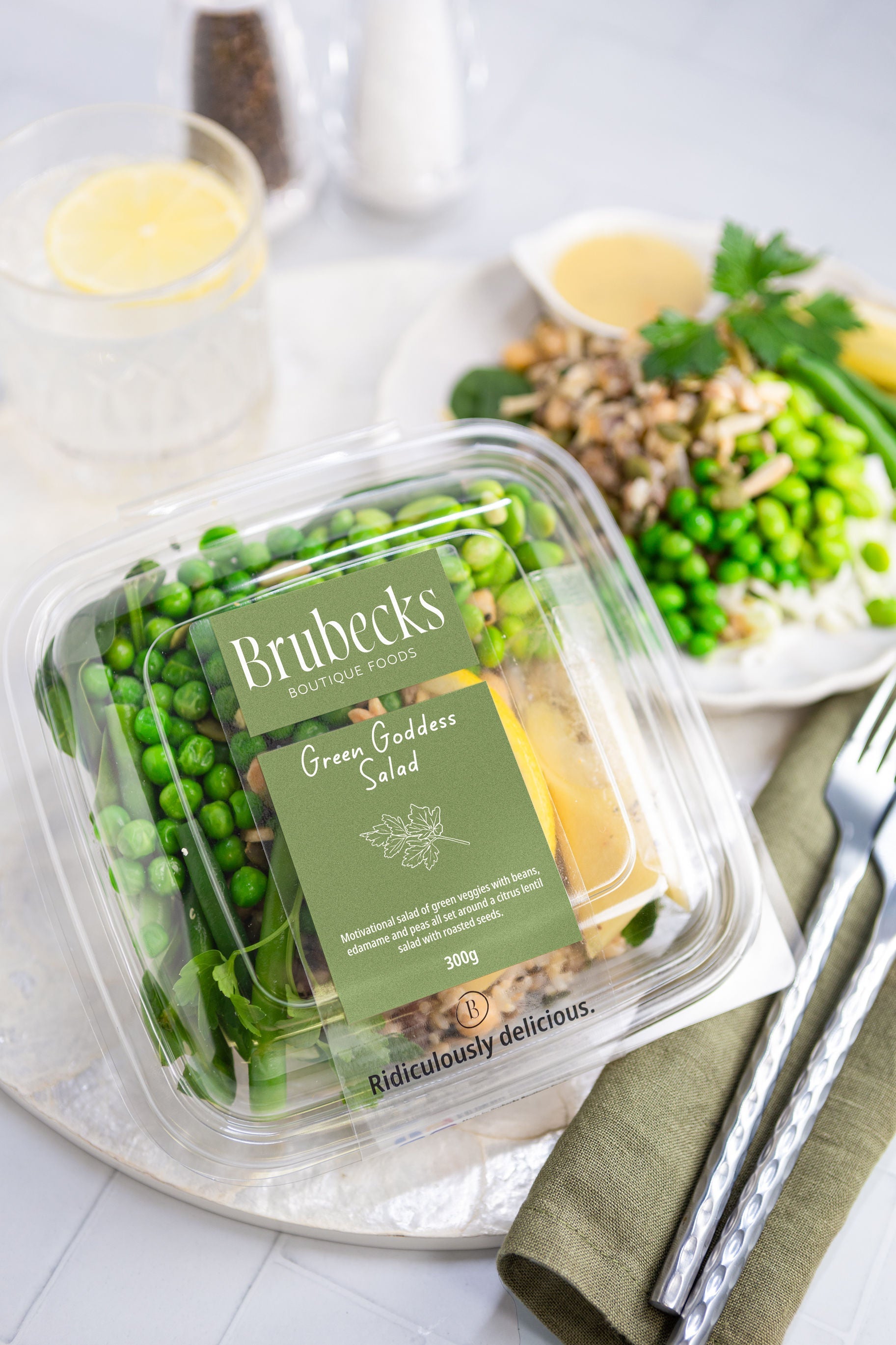 Brunecks Green Goddess Salad packaging on a table with a salad in the background