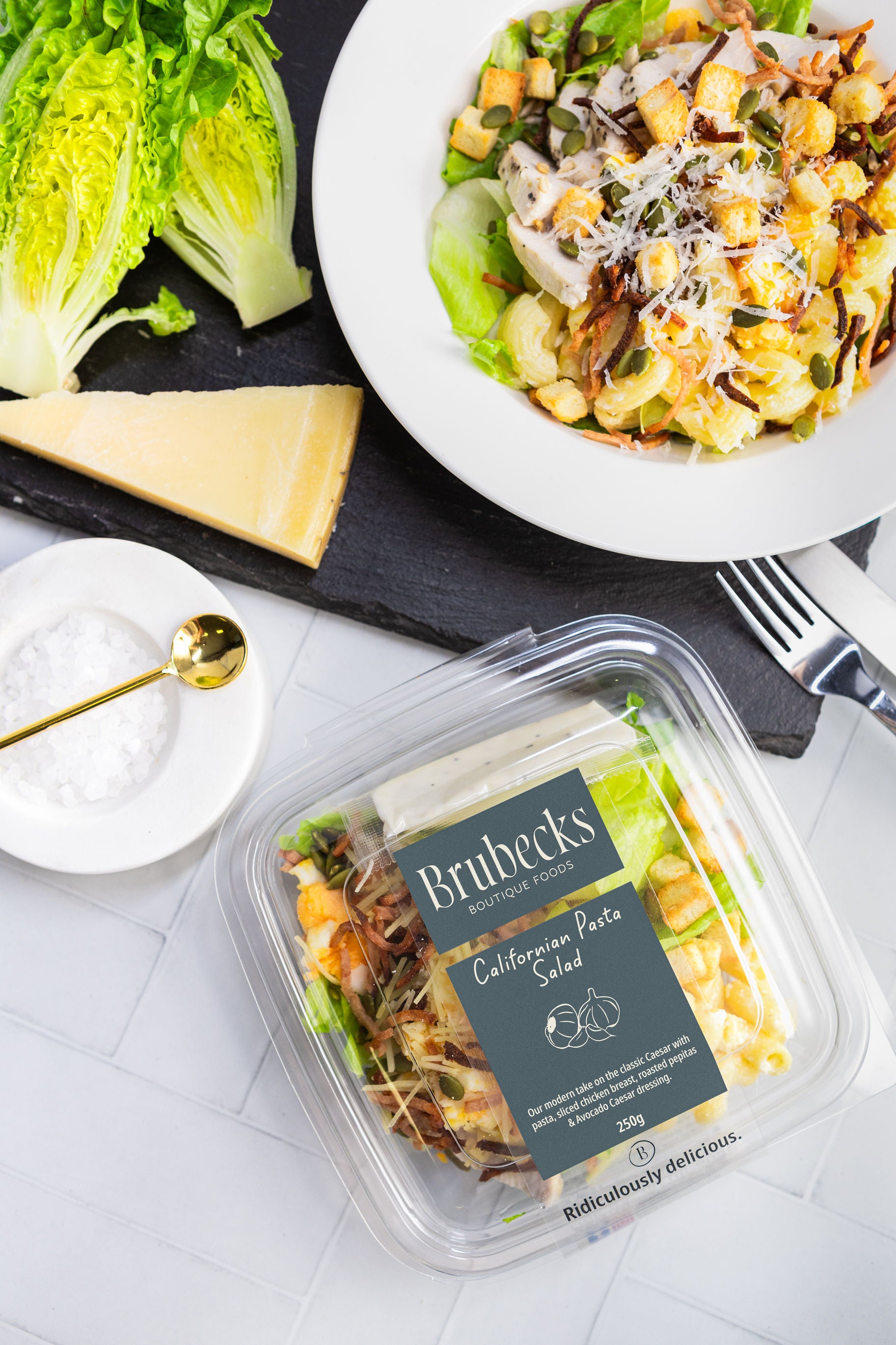 Brubeck's California Pasta Salad packaging with a salad and cheese on a table.