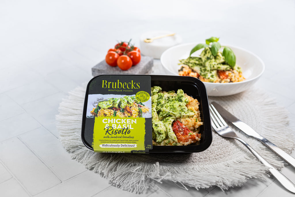 Brubecks Chicken and Rice Risotto packaging on a table with a bowl of salad and tomatoes.