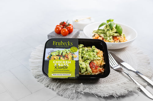 Brubecks Chicken and Rice Risotto packaging on a table with a bowl of salad and tomatoes.