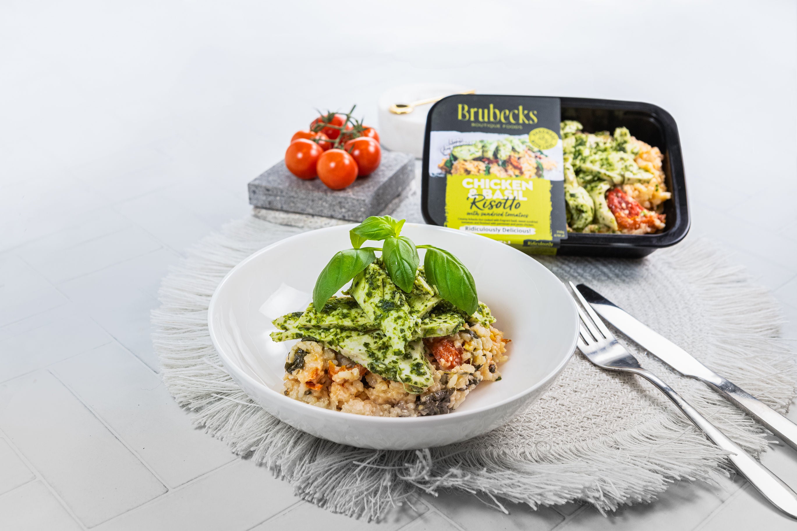 White bowl with a salad on a gray surface, next to a Brubecks food container.