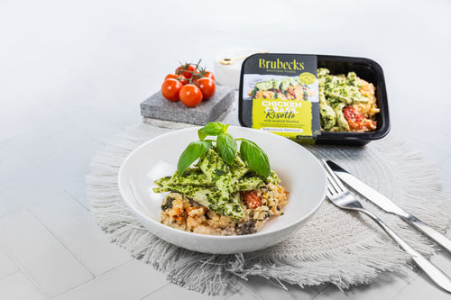 White bowl with a salad on a gray surface, next to a Brubecks food container.