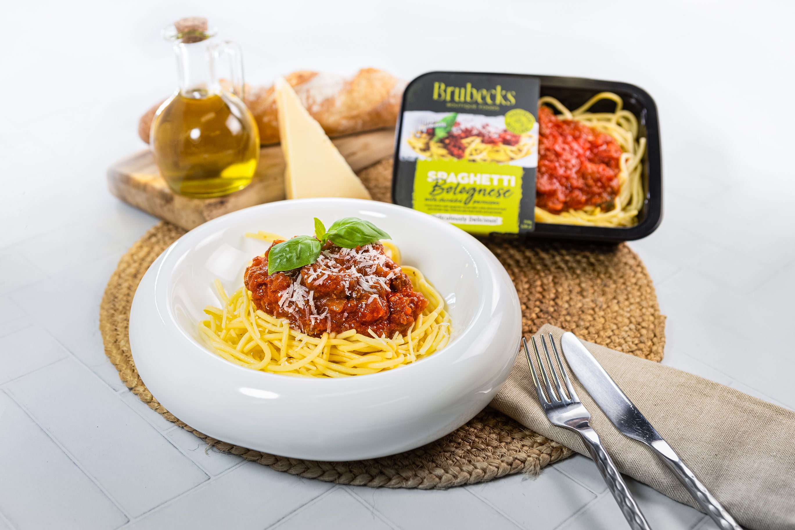 Spaghetti dish with Brubeck's Bolognese sauce packaging on a white surface