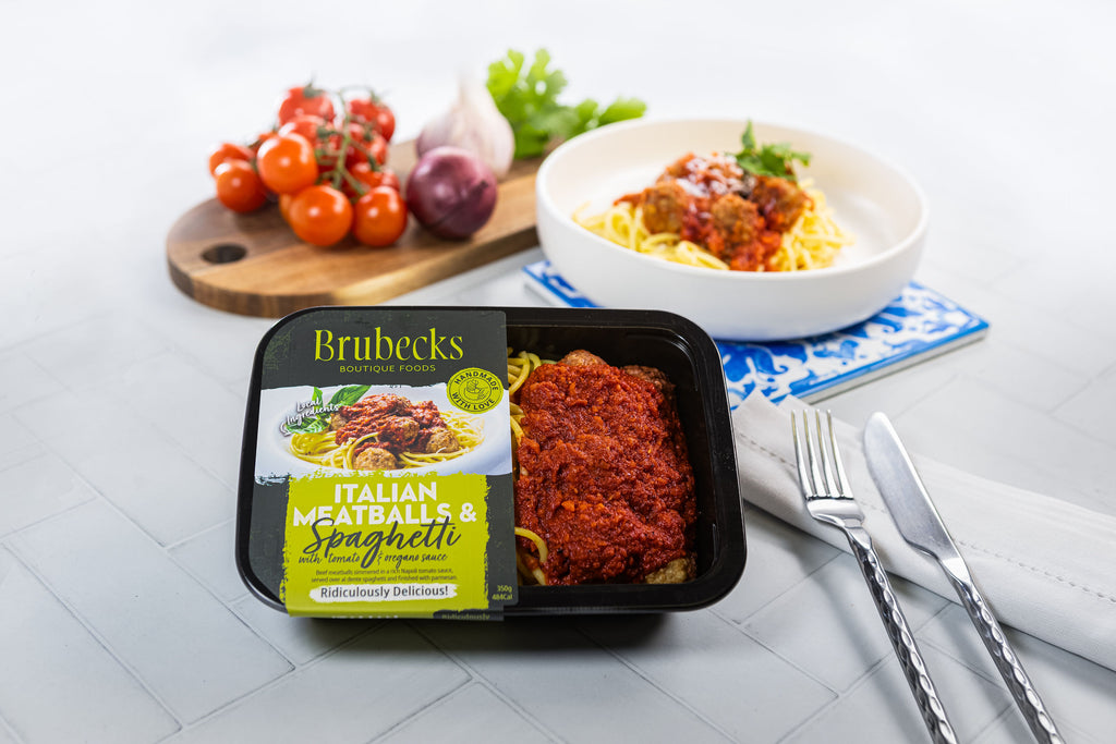 Brubecks Italian Meatballs & Spaghetti meal kit with a bowl of pasta and vegetables on a table.