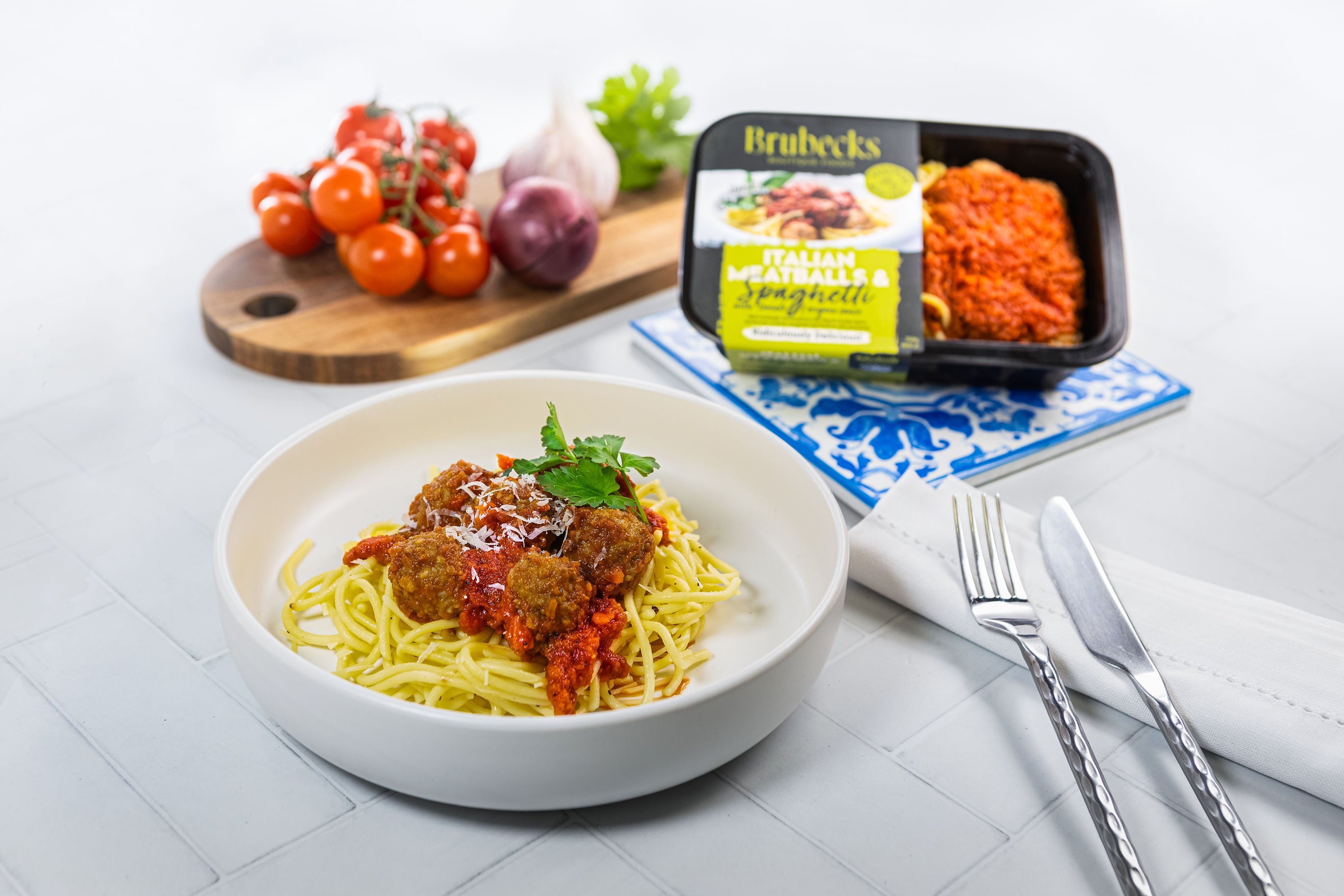 Bowl of spaghetti with meatballs on a table with Brubeck's Italian Meatballs packaging.