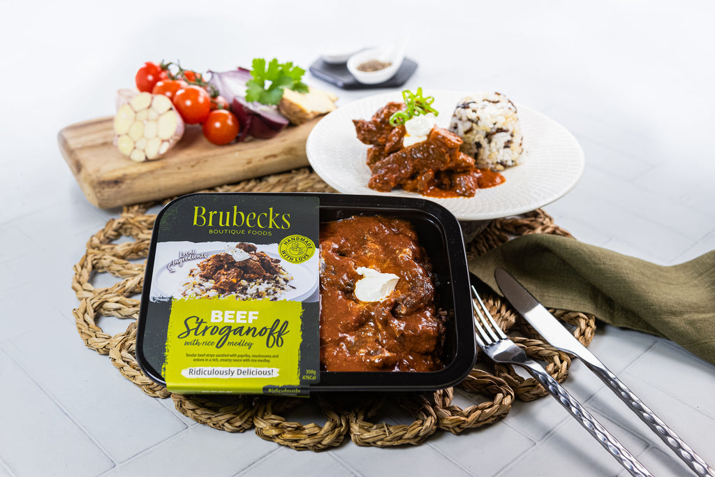 Brubecks Beef Stroganoff package on a table with a dish of food and utensils.