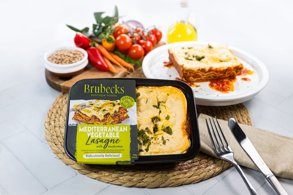 Brubecks Mediterranean Vegetable Lasagne with a plate of lasagne and vegetables on a table.