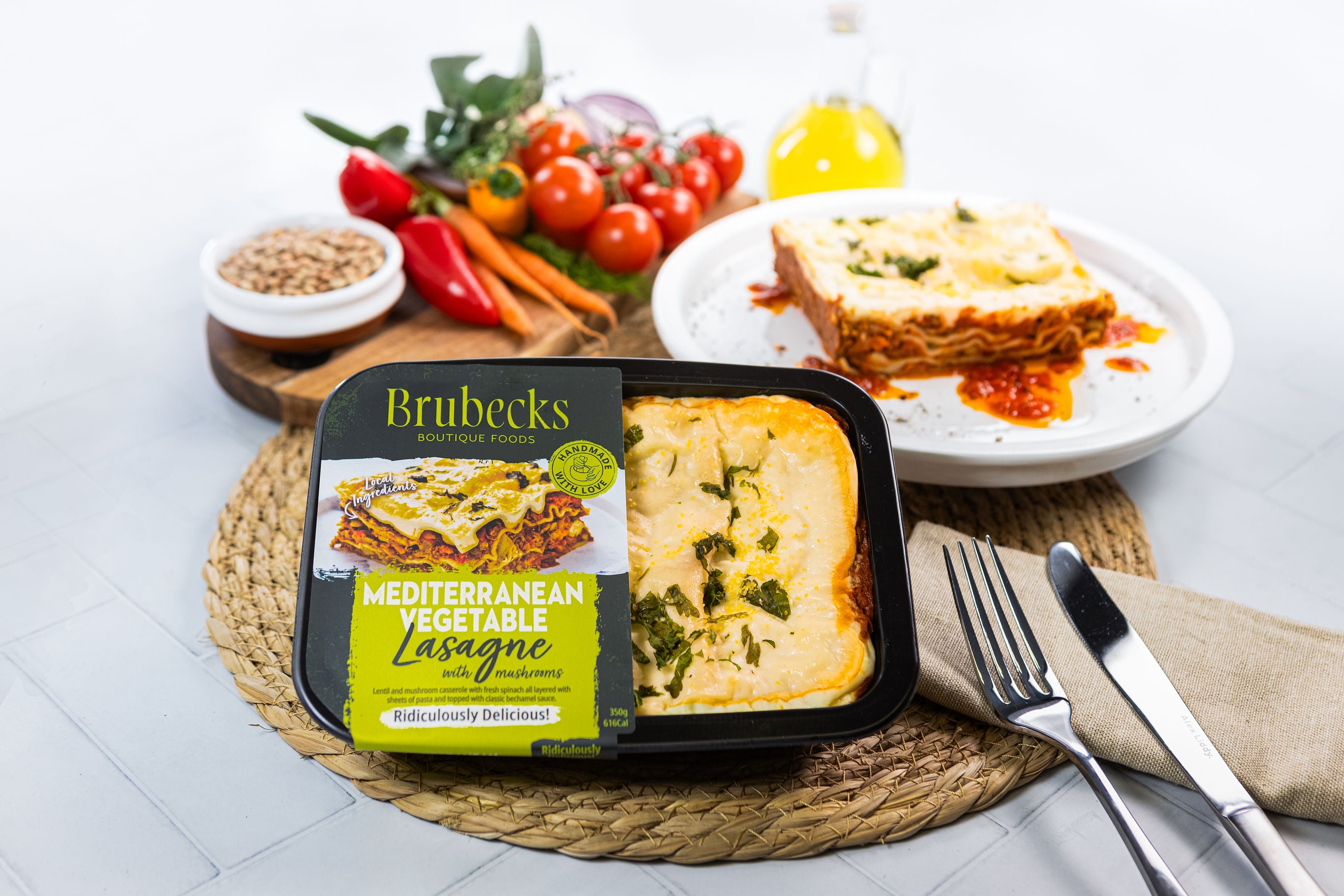 Brubecks Mediterranean Vegetable Lasagne with a plate of lasagne and vegetables on a table.