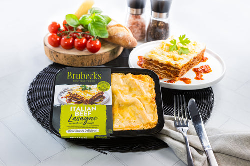Brubecks Italian Beef Lasagne package on a table with a plate of lasagne and vegetables.