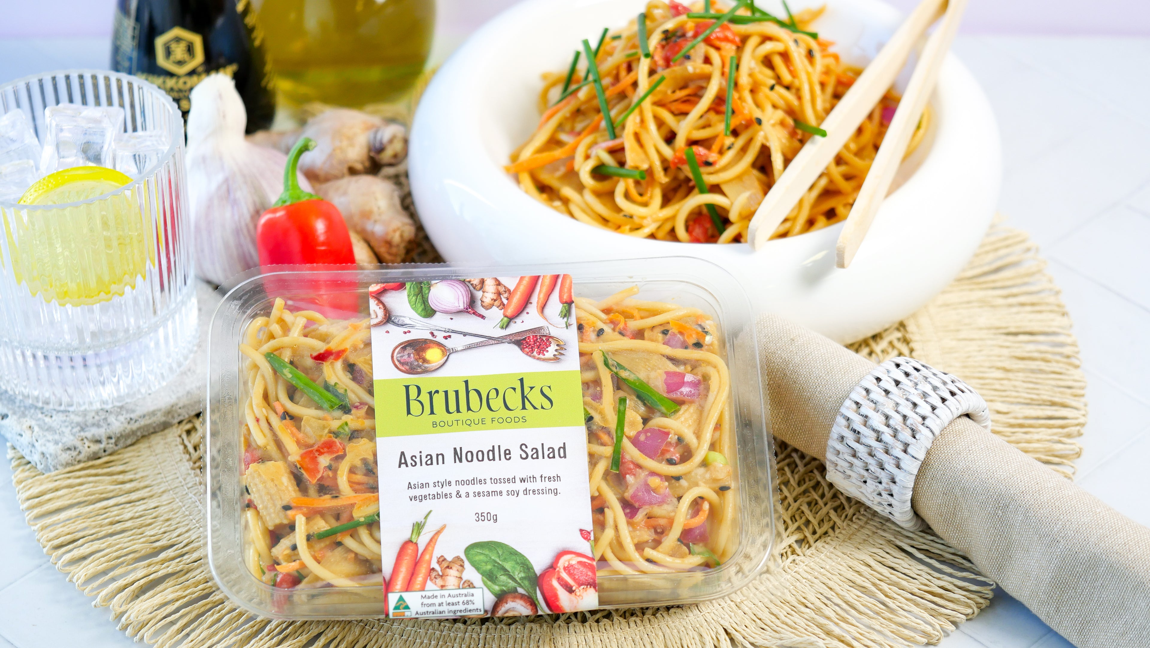 Brubecks Asian Noodle Salad packaging with a bowl of salad and utensils on a table.