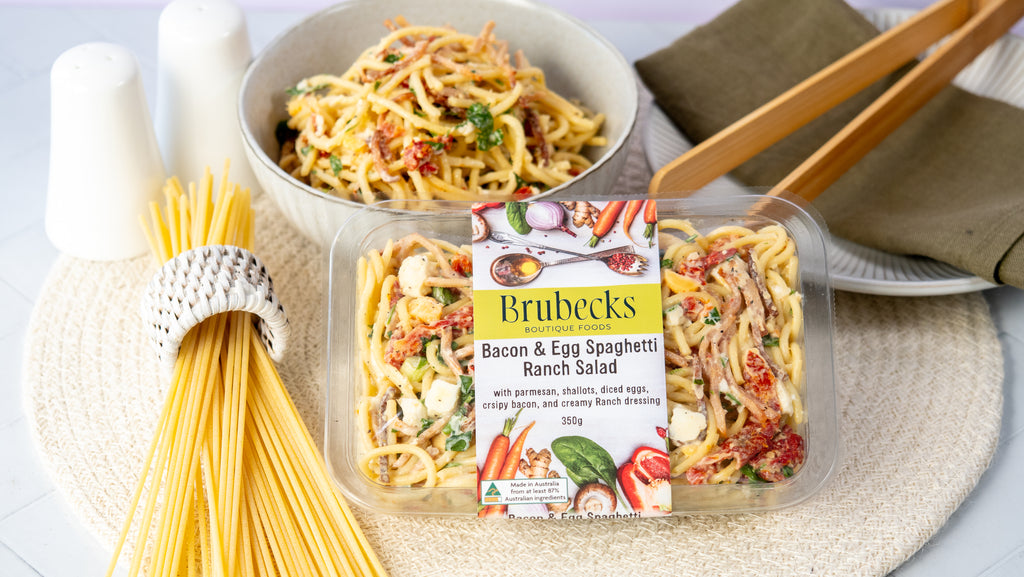 Brubecks Bacon & Egg Spaghetti Ranch Salad package with spaghetti and salad on a table.
