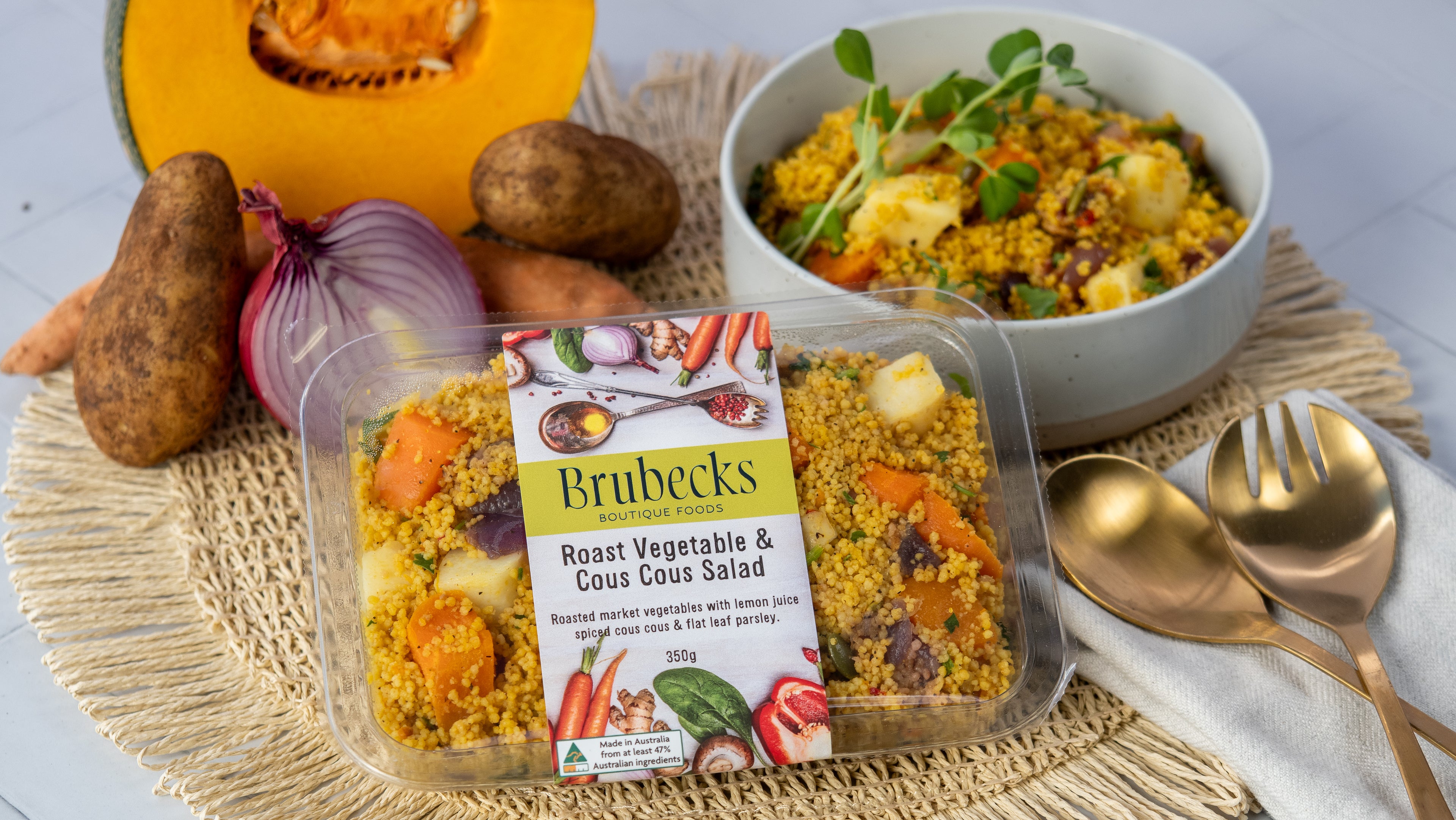Brubeck's Roast Vegetable & Couscous Salad packaging with a bowl of salad and ingredients on a table.