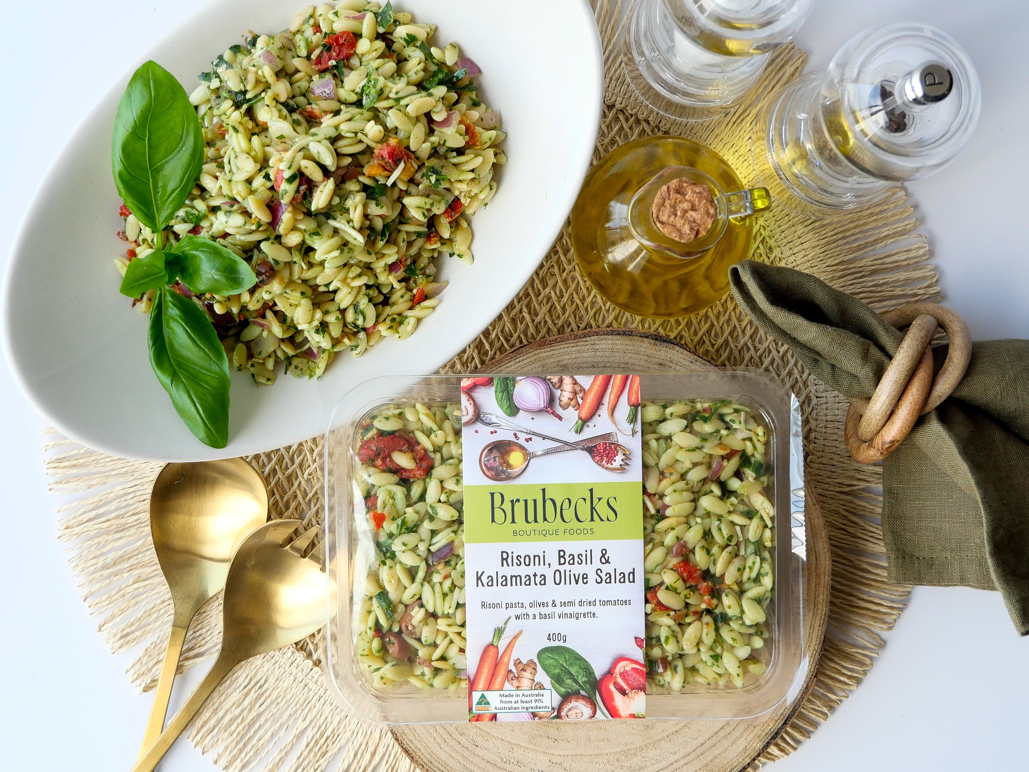 Brubeck's Risoni, Basil & Kalamata Olive Salad packaging with a bowl of salad on a table.
