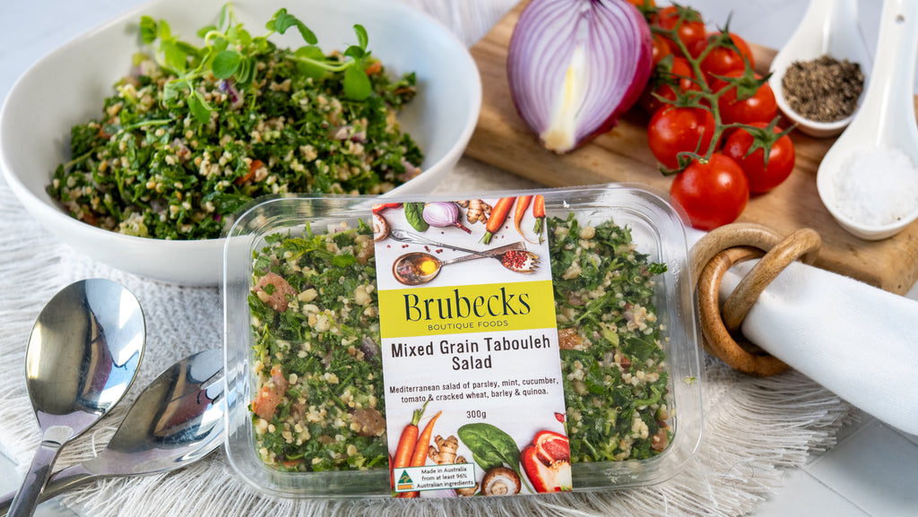 Brubecks Mixed Grain Tabouleh Salad packaging with a salad and ingredients on a table.