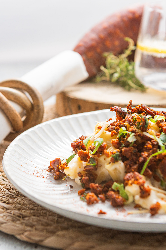 Brubecks dish with meat and cheese on a white plate, blurred background